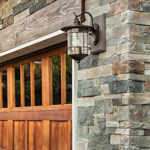 Stone veneer exterior with wooden garage doors on a Villanova home